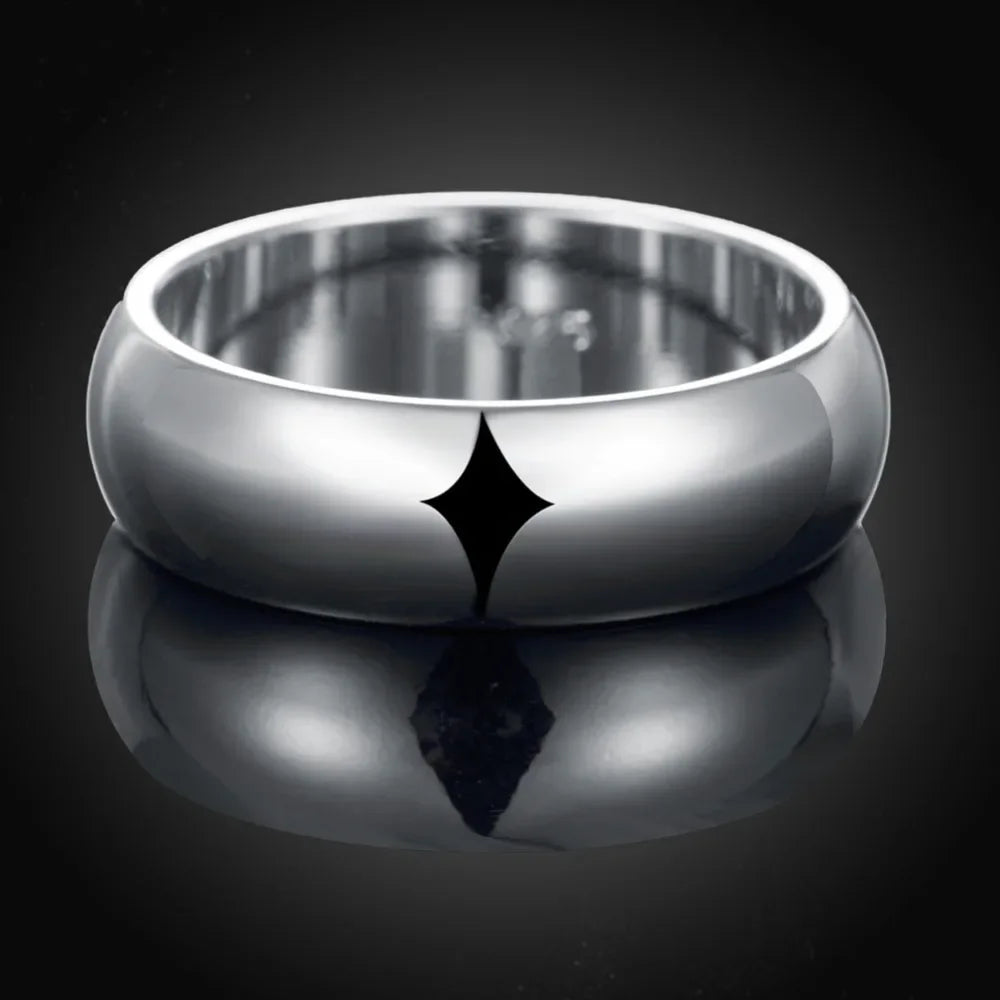 Silver ring with a reflective surface on a black background