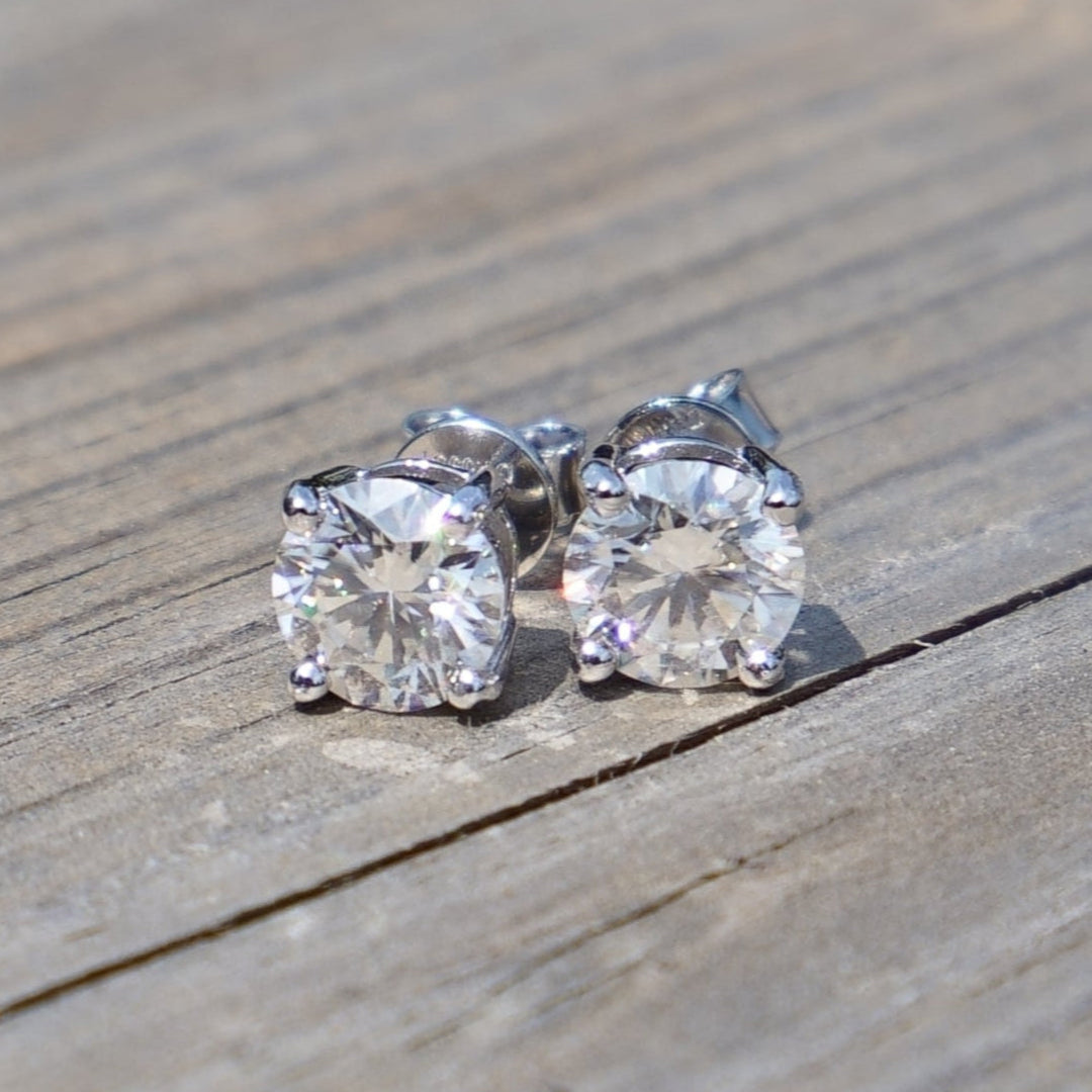 Moissanite stud earrings on a wooden surface