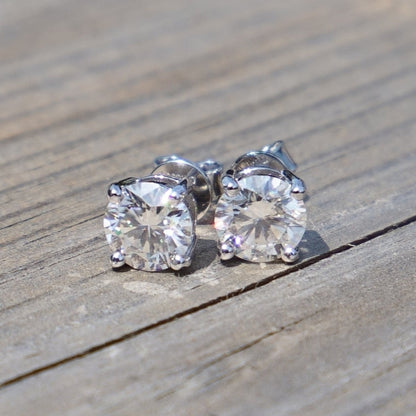 Moissanite stud earrings on a wooden surface