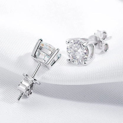 Pair of moissanite stud earrings on a white fabric background